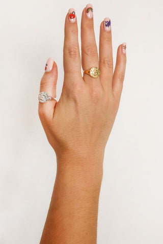 close-up-image-of-a-hand-with-painted-nails-wearing-gold-rings-including-that-of-the-spell-s-stargazer-zodiac-ring